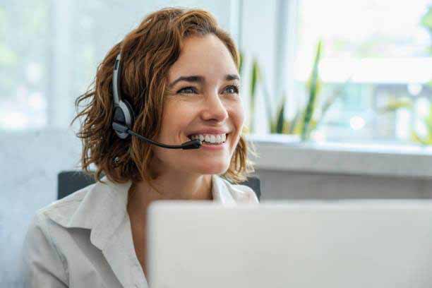 Close-up of smiling mature female customer service representative wearing headset in office